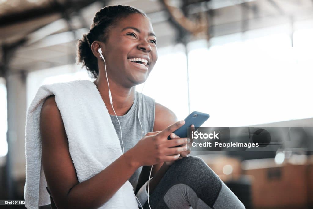 Athlete with phone and earbuds in gym